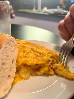 a person eating a piece of food on a plate with a fork at Habitación geniale cerca de Russafa in Valencia