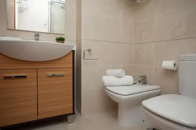 a bathroom with a sink and a toilet and a mirror at SingularStays Oceanic in Valencia
