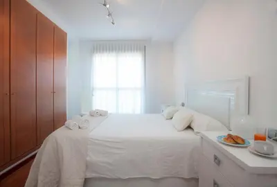 a white bedroom with a bed with towels on it at SingularStays Oceanic in Valencia