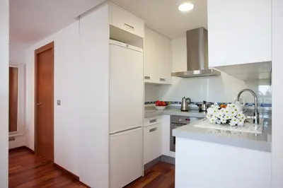 a kitchen with white cabinets and a sink at SingularStays Oceanic in Valencia