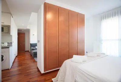 a bedroom with a large wooden cabinet with towels on a bed at SingularStays Oceanic in Valencia