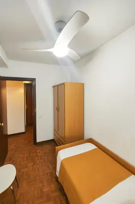 a bedroom with a bed and a ceiling fan at Apartamento Familiar En Nuevo Centro - Parque Central Turia in Valencia