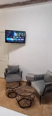 a living room with two couches and a tv on the wall at Suite centro con cocina in Valencia