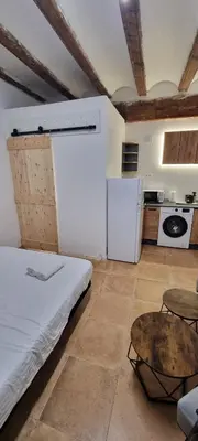 a room with a bed and a table and a kitchen at Suite centro con cocina in Valencia
