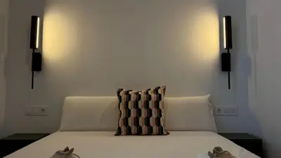 a bedroom with a bed with a black and white pillow at Boutique Room - Vila Prades in Valencia