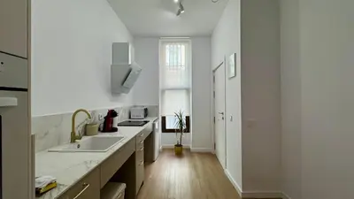a white kitchen with a sink and a window at Boutique Room - Vila Prades in Valencia