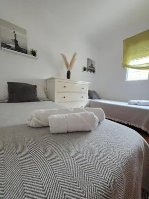 a bedroom with a bed and a dresser with towels on it at Villa Entre-Azahar, Tu refugio de tranquilidad in Lliria