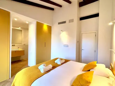 a bedroom with a large white bed with yellow pillows at Casa Tossal in Valencia