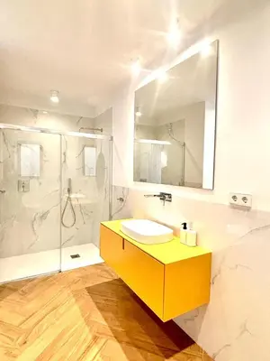 a bathroom with a yellow sink and a shower at Casa Tossal in Valencia