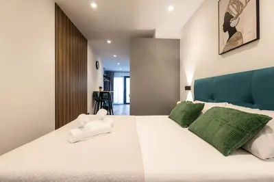 a bedroom with a large white bed with green pillows at Cielo y Mar in Valencia
