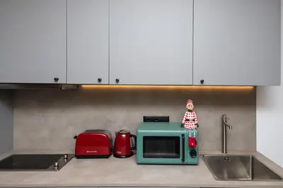 a toy doll sitting on a microwave in a kitchen at Cielo y Mar in Valencia