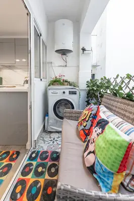 a living room with a couch and a washing machine at Valencia Designer Apartment next to metro in Paterna