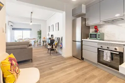 a kitchen and living room with a couch and a stove at Valencia Designer Apartment next to metro in Paterna