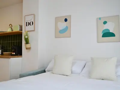 a bedroom with a bed with white sheets and pillows at Ruzafa & Oceanografic Suites by Illetes Flats in Valencia