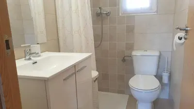 a bathroom with a white toilet and a sink at Adosado acogedor en la Cañada con piscina privada in Partida de La Cañada