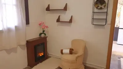a living room with a chair and a fireplace at Adosado acogedor en la Cañada con piscina privada in Partida de La Cañada