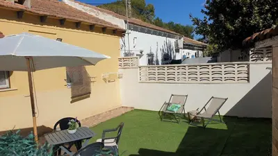 a patio with a table and chairs and an umbrella at Adosado acogedor en la Cañada con piscina privada in Partida de La Cañada