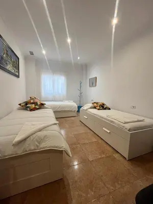 a bedroom with two beds and a window at Terraza 120 m2 y paellero - Metro & Aeropuerto in Manises