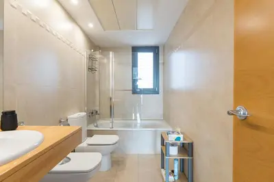 a bathroom with a tub and a toilet and a sink at Loft Doble Altura con Terraza Panorámica y Piscina in Burjasot