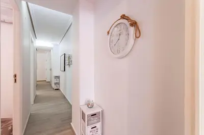 a white hallway with a clock on the wall at Valencia Flat Rental 3 bedroom in Extramurs in Valencia