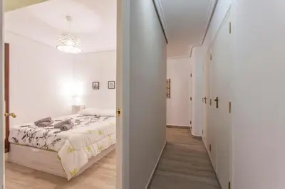 a white bedroom with a bed and a hallway at Valencia Flat Rental 3 bedroom in Extramurs in Valencia