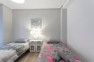 a bedroom with two beds and a table with a lamp at Valencia Flat Rental 3 bedroom in Extramurs in Valencia