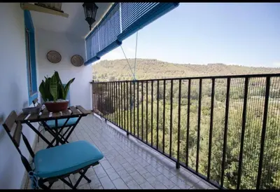 a balcony with a chair and a table and a view at Casa con vistas al rio in Navajas