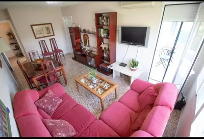 a living room with a pink couch and a table at Casa con vistas al rio in Navajas