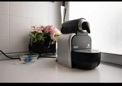 a coffee maker on a counter next to a vase of flowers at Casa con vistas al rio in Navajas