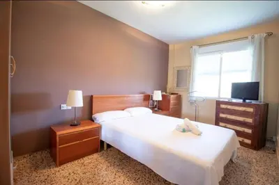 a bedroom with a large white bed and a television at Casa con vistas al rio in Navajas