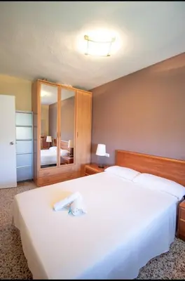 a bedroom with a large white bed with a mirror at Casa con vistas al rio in Navajas