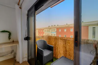 a balcony with a chair and a view of a building at Cabañal BeachFront , 1 Min to Sea , AC , Coffee , Balcony , FastWifi in Valencia