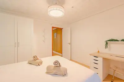 a white bedroom with a bed and a desk at Cabañal BeachFront , 1 Min to Sea , AC , Coffee , Balcony , FastWifi in Valencia