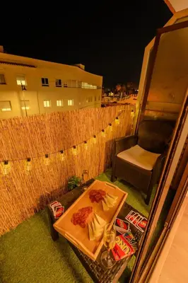 a table with food and a chair on a balcony at Cabañal BeachFront , 1 Min to Sea , AC , Coffee , Balcony , FastWifi in Valencia