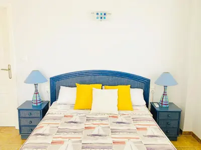 a bedroom with a bed with yellow pillows and two lamps at Villa en la Playa I 5BR I 5 WC I Piscina Privada in Sueca