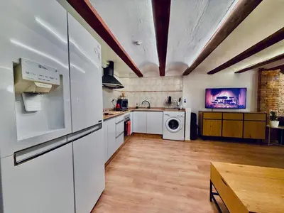 a large kitchen with white appliances and a table at Duplex en el Carmen in Valencia