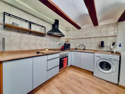 a kitchen with white cabinets and a washer and dryer at Duplex en el Carmen in Valencia