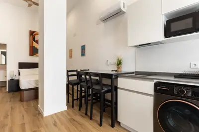 a kitchen and dining room with a washer and dryer at Urban loft Benicalap in Valencia