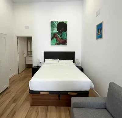 a bedroom with a bed and a couch at Urban loft Benicalap in Valencia