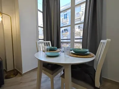 a dining room table with chairs and a window at Apartment Ruzafa Market 6B in Valencia