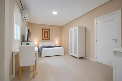 a bedroom with a bed and a desk and a sink at Apartment Ruzafa Market 6A in Valencia