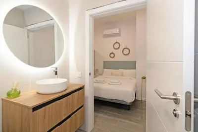 a bathroom with a sink and a bed with a mirror at GuestReady - Fontilles apartments in Valencia