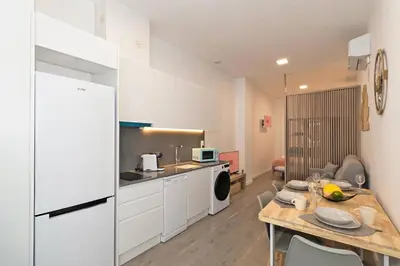 a kitchen with a table and a white refrigerator at GuestReady - Fontilles apartments in Valencia
