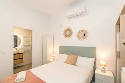 a white bedroom with a bed and a bathroom at GuestReady - Fontilles apartments in Valencia