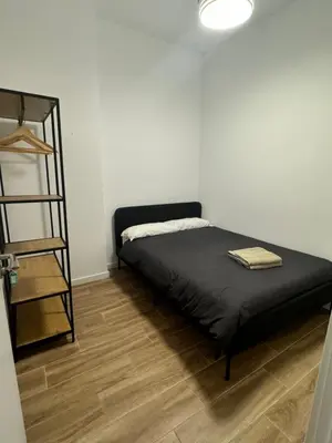 a bedroom with a black bed and a book shelf at Habitacion privada con baño privado II in Valencia