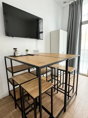a dining room table with chairs and a tv on the wall at Habitacion privada con baño privado II in Valencia