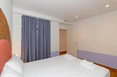 a bedroom with a white bed and a blue curtain at GuestReady - Stay near the Central Market in Valencia