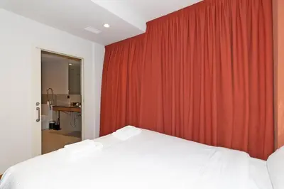 a bedroom with a bed and a red curtain at GuestReady - Stay near the Central Market in Valencia
