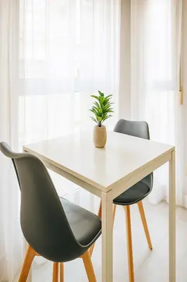 a white table with two chairs and a potted plant at Apartment Ruzafa Market 7B in Valencia