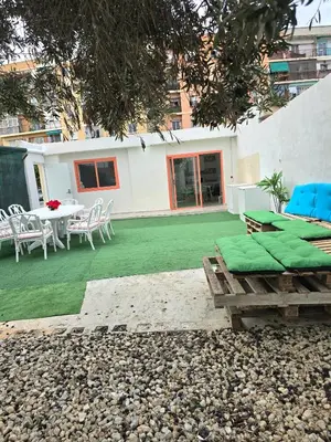 a house with a green yard with a table and chairs at La Casita de Beni Valencia in Valencia
